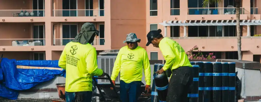 Waterproofing crew staging membrane rolls on site